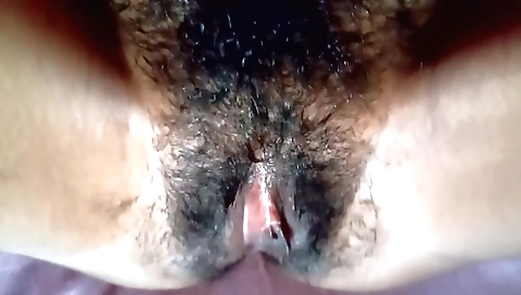 Indian slut with a sexy face plays with her hairy pussy