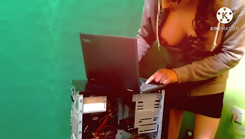 Indian girl in sexy down blouse is fixing her laptop